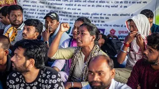 Group of people sitting on the flood, chanting slogans during a protest in India's Jharkhand state