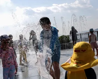 Children cool off in a water fountain at a Hong Kong park on Sunday as the city reached a record temperature of 36.9C