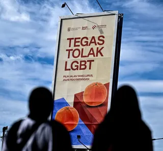 Pedestrians walk past a hoarding that reads “Firmly reject LGBT” in Banda Aceh on July 27. Anti-LGBTQ sentiment is rising in Indonesia. Photo: AFP