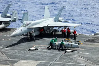 Flight deck crew move a fuel tank from a fighter jet on the USS Theodore Roosevelt aircraft carrier during military exercises. Photo: Reuters