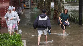 Residents wade through flooded streets in Shanghai