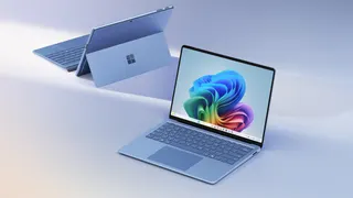 A Microsoft Surface and Surface Pro laptops on a grey/blue gradient background
