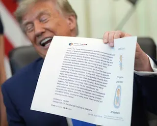 Trump holds up an image taken from his Truth Social account during an order signing about vaccines.