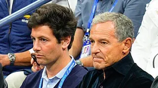 Joshua Kushner (L) and Bob Iger watch tennis