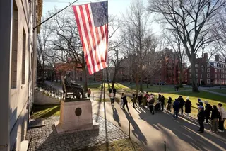 FILE - People take photos near a John Harvard statue, left, on the Harvard University campus, Jan. 2, 2024, in Cambridge, Mass. (AP Photo/Steven Senne, File)