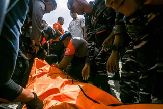 Rescue and military personnel handle the body bag of a dead victim at Lembar port in West Lombok on August 12, 2026. A navy vessel and other ships rushed in on August 12 to rescue over 100 people from a ferry on fire off the Indonesian tourist island of Bali, officials said, in the second such incident in days. — AFP pic