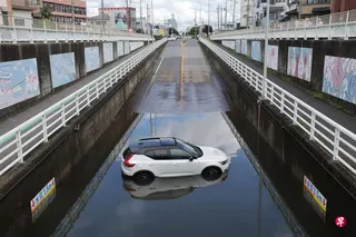 8月14日，日本千叶县镰谷市一处地下通道内，一辆汽车困在积水中无法动弹。 （法新社）