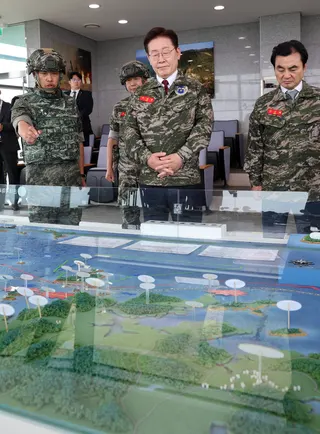South Korean President Lee Jae Myung (centre) and Defence Minister Ahn Gyu-back (right) listen to a military officer at an observatory on Yeonpyeong Island in South Korea in June. Photo: EPA