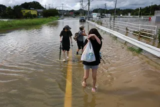 大网白里市强降雨过后，多处洪水星期五（8月14日）仍未消退，当地居民外出时得涉水行走。（路透社）