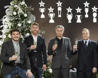 Real Madrid’s goalkeeper Iker Casillas, defender Sergio Ramos, manager José Mourinho and president Florentino Pérez pose with champagne glasses in front of a Christmas tree.