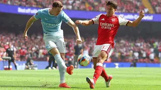 Manchester City's Elliot Anderson and Arsenal's Christos Tzolis battle for the ball, which can be seen just off the floor between both players