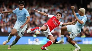 Christos Tzolis fights for the ball under pressure from Manchester City duo Abdukodir Khusanov and Rico Lewis