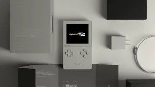 A picture of a special “Developer” variant of the Analogue Pocket, shown in white surrounded by packaging and accessories. The screen displays “openFPGA,” Analogue’s branding for its third-party core support.