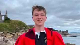 哈里森夏普爾斯正看著鏡頭微笑。他穿著一件紅色的碼頭漫步長袍。