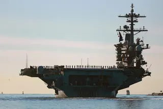 Sailors and Marines line the deck of the USS Abraham Lincoln as it deploys from San Diego in January 2021. Photo: The San Diego Union-Tribune via AP