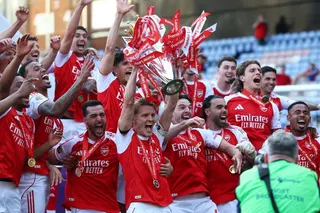 Arsenal's Martin Odegaard lifts the trophy as he celebrates with teammates.