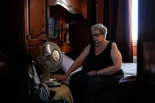A woman turns on the fan in a bedroom of her flat at Place des Fetes during a hot summer day in Paris on July 29. Photo: AFP