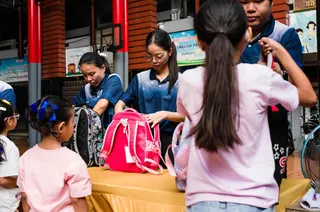 Staff inspect backpacks due to new security measures as students arrive at Sawasdee Wittaya School in Bangkok on August 14, 2026. — AFP pic