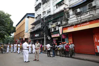 Firefighters and other officials stand on the street in the aftermath of hotel a fire that killed several people in Kolkata on Wednesday. Photo: Reuters