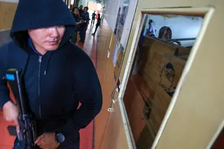 A police officer acting as an active shooter holds a rifle and walks past a classroom as students hide during a drill to prepare for an active shooter scenario at Surasamontree School in Bangkok, Thailand, on Wednesday. Photo: Reuters