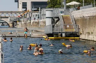 People swim next to the banks of the River Seine, as part of Paris en Seine events, at the Bercy swimming site during a heatwave in Paris, France, on August 14. Photo: EPA