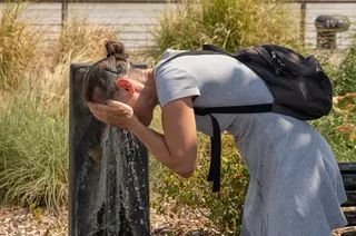A woman splashes water on her face at a public fountain on a hot day in Bordeaux, France, on August 13. Photo: AP