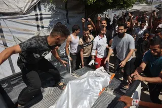 EDITORS NOTE: Graphic content / Displaced Palestinians carry the body of a victim away from the site of an Israeli strike that targeted the municipal police headquarters in Gaza City on August 19, 2026.