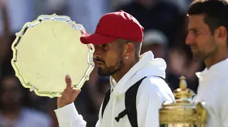 Nick Kyrgios walks off with the Wimbledon singles runner-up trophy after losing the 2022 final to Novak Djokovic