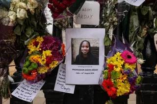 Flowers are tied to the gates along with a photo of Jason Arday