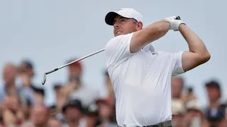 Rory McIlroy swings on the 7th hole at a golf course.