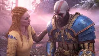 An image from God of War (2018) showing Faye, a red-haired woman with a yellow and blue tunic on, putting a hand on her husband, Kratos' plated shoulder.