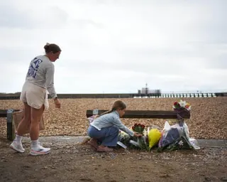 A mother and daughter lay flowers on the beach at Shoreham-by-Sea