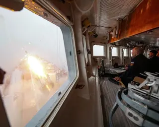 Putin watches a missile launch from a naval cruiser's cabin window during a military drill