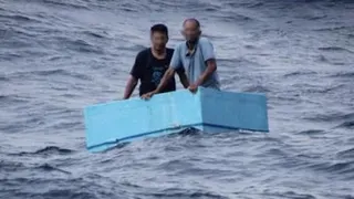 Two men inside a cooling box in the middle of the sea