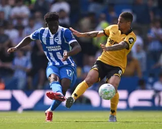 Brighton's Carlos Baleba passes the ball under pressure from Wolves' João Gomes