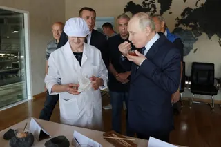 Russian President Vladimir Putin tries caviar during his visit to a fish processing complex on the Southern Kuril Island of Iturup on August 13. Photo: Sputnik via Reuters