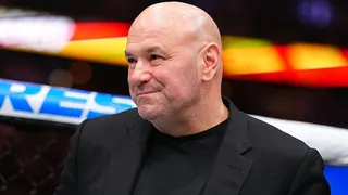 Dana White smiles and is wearing a black jacket