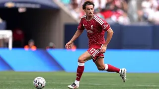 Curtis Jones running with the ball in Liverpool's 2026-27 red home kit