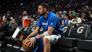 Klay Thompson sits on the bench during warmups