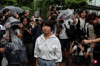 三名曾组织“六四”烛光晚会的人士，8月21日被裁定煽动颠覆国家政权罪名成立。图为香港前“支联会”领袖李卓人的妻子邓燕娥，当天离开西九龙裁判法院的神情。 （路透社）