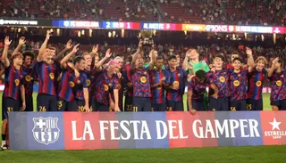 Barcelona’s Raphinha lifts the Joan Gamper trophy as the teammates celebrate after beating Al Ahly in the club’s final preseason friendly