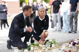 The Swedish prime minister, Ulf Kristersson, (L) and the Social Democratic party leader, Magdalena Andersson, visit the makeshift memorial.