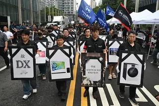 2026年8月21日，南韓首爾瑞草區的三星城，包含手機和家電在內的數位轉型部門工會成員遊行抗議，手上拿著該部門製造過的產品儀照，要求針對薪酬問題再進行談判​​。（法新社）