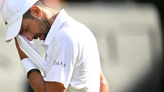 Novak Djokovic wipes his face