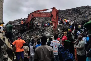 当地时间周日凌晨，几内亚首都科纳克里达累斯萨拉姆垃圾掩埋场发生山崩，居民和救援人员使用挖土机搜寻罹难者遗体。（图取自法新社）