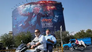 Motorcyclists in Tehran pass a billboard depicting President Donald Trump underwater amid explosions with the words "Great Victory! Strait of Hormuz," on August 24, 2026