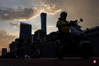 今年7月6日，北京中央商务区夕阳下，一名外卖员骑车经过中信大厦。 （路透社档案照片）