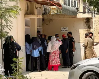 Relatives of the victims gather outside the mortuary of the Pakistan hospital after the fire.