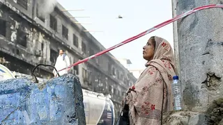 Woman looking downtrodden while standing in the middle of debris