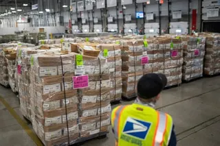 a worker stands in a  USPS processing center